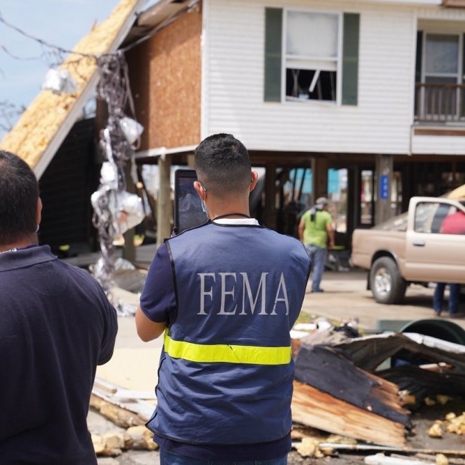 FEMA first responders survey the scene of a house that has sustained damage.