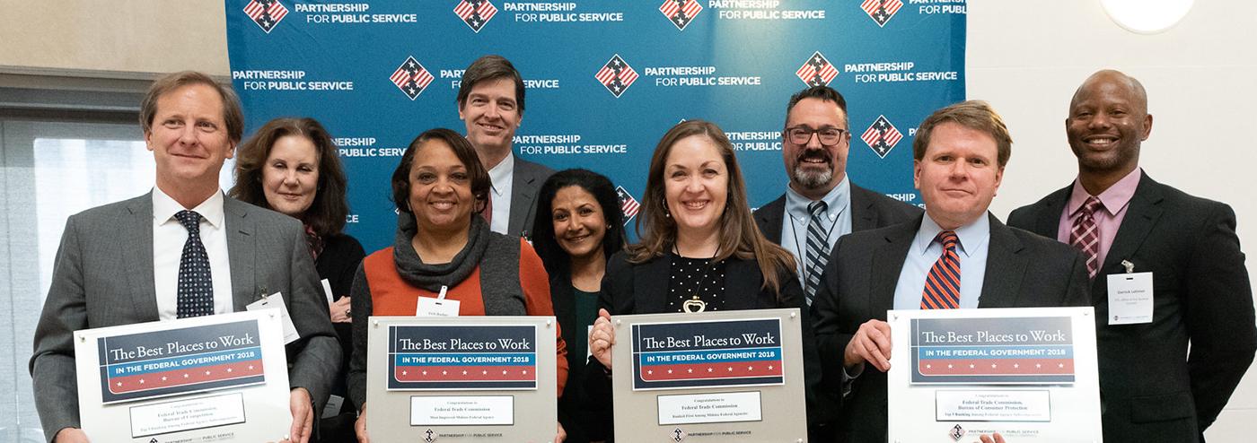 Group of people holding Best Places to Work signs