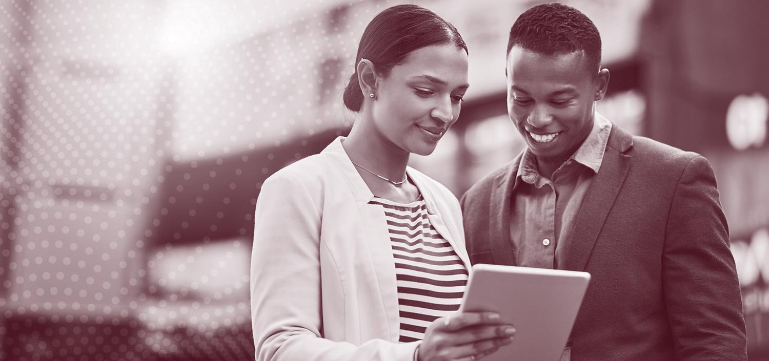 Magenta filtered image of a two people looking at tablet together