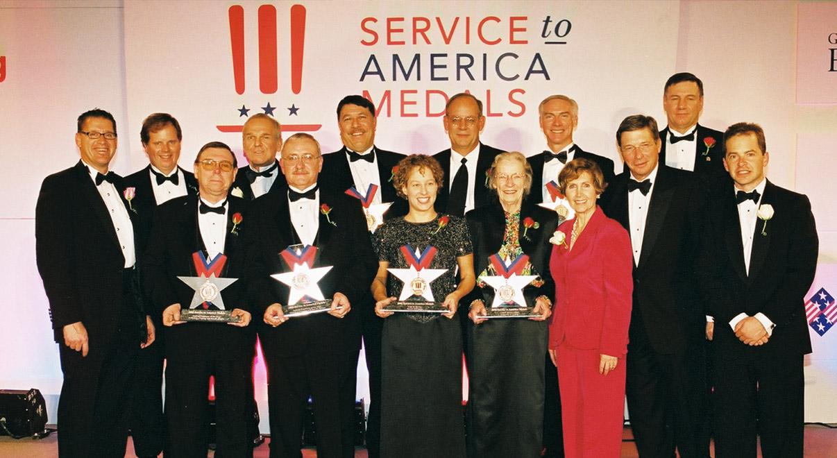 Diverse group of people holding awards