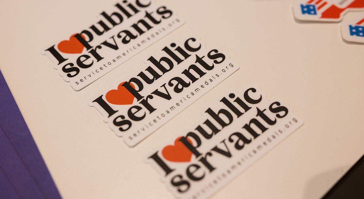 “I love public servants” stickers displayed on a table.