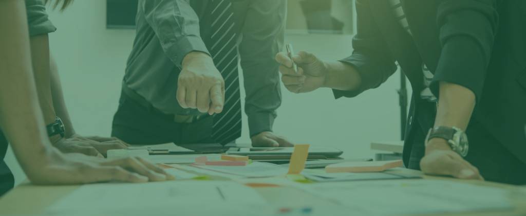 Teal filtered image of people pointing at post-it notes