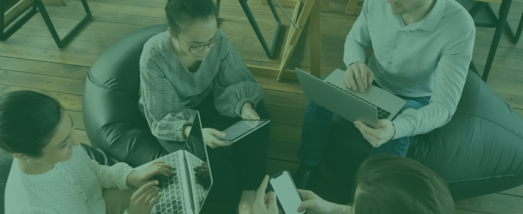 Teal filtered image of a diverse group working on laptops and tablets